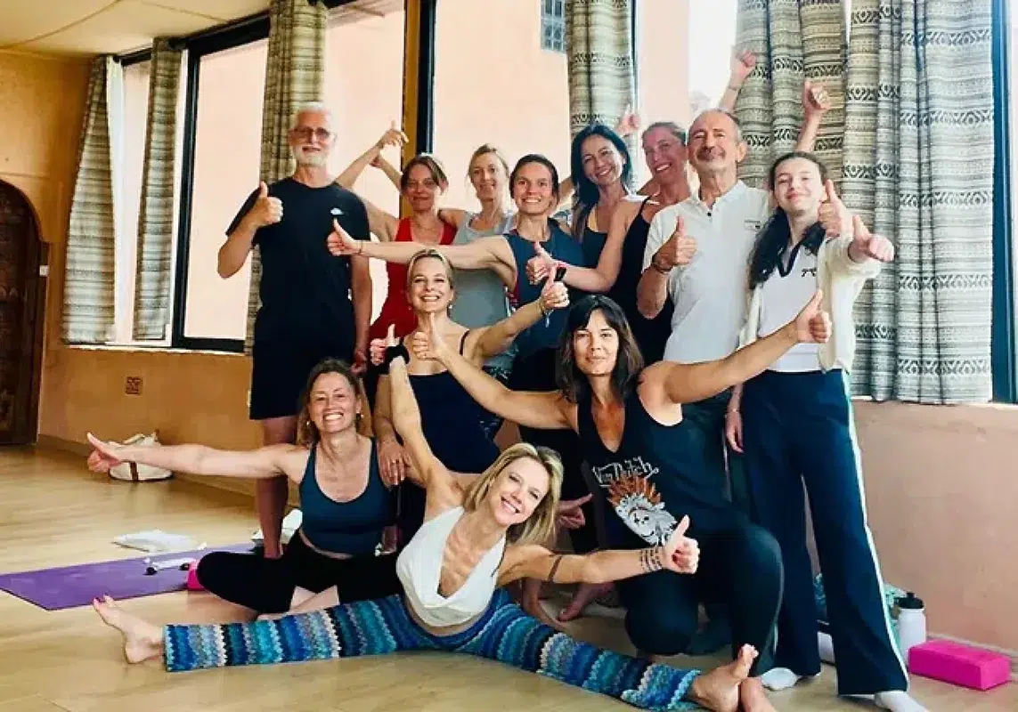 Groupe de personnes souriantes faisant du yoga