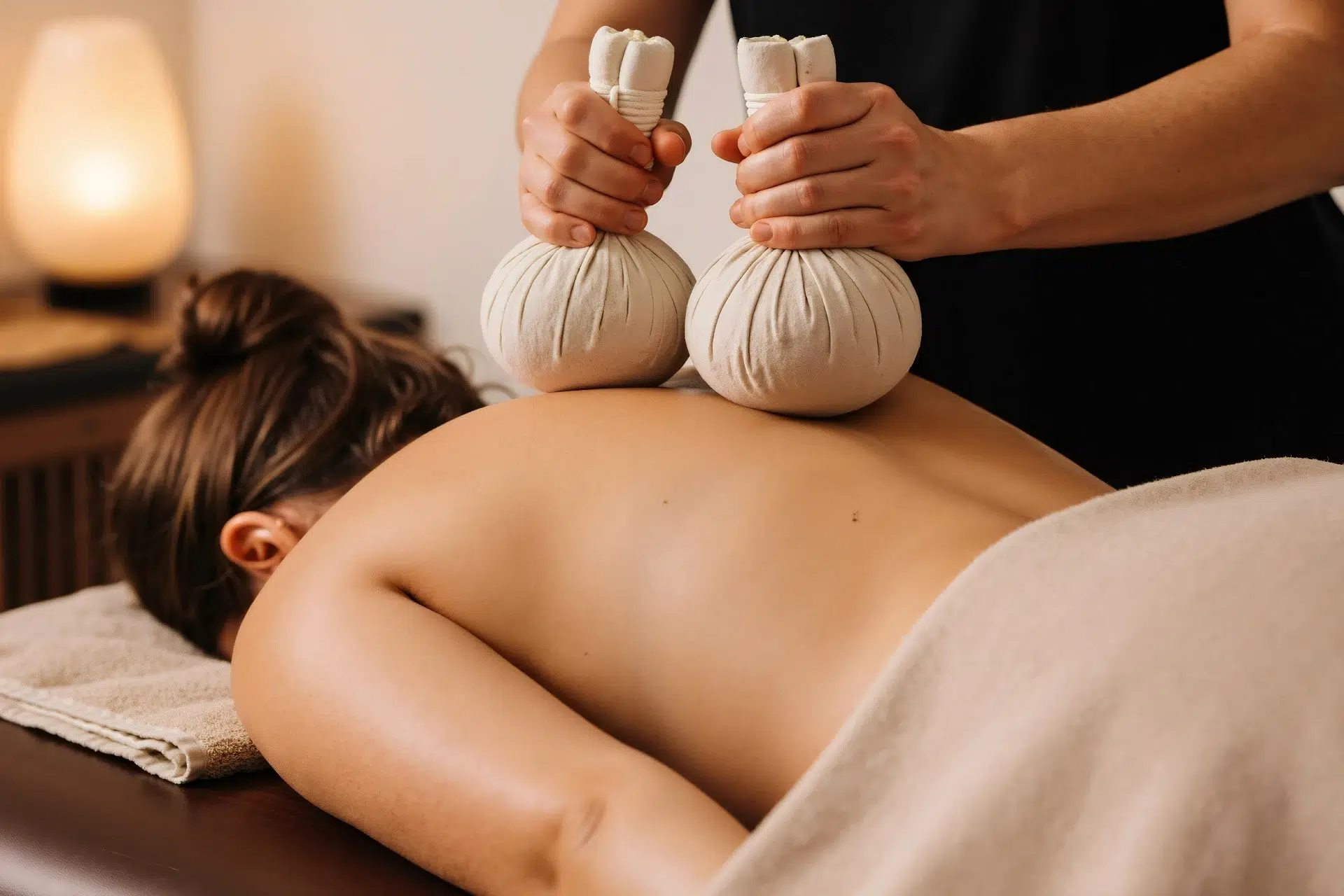 Massage aux pochons d'herbes sur le dos